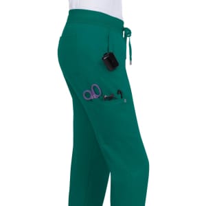 A pair of green jogger pants featuring multiple pockets with scissors and a small black device attached.