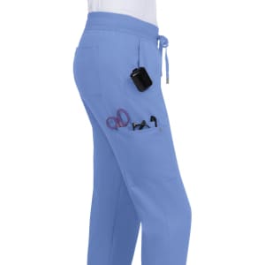 Light blue jogger pants with pockets, featuring scissors and other tools clipped inside.