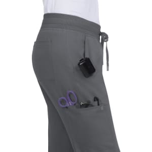 A pair of grey jogger pants featuring pockets, with scissors and pens visible. There is also a clip-on device attached.