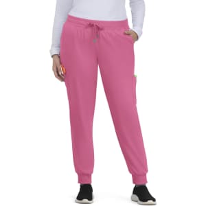 A pair of pink jogger pants with pockets and a drawstring waist, worn by a person standing with hands in pockets.
