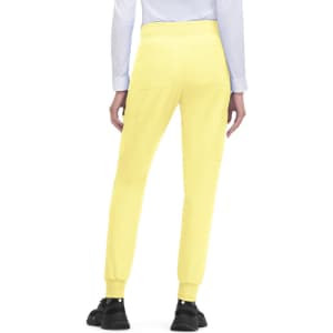 A pair of yellow joggers with pockets, featuring tapered legs and elastic cuffs, worn with a light-coloured top.
