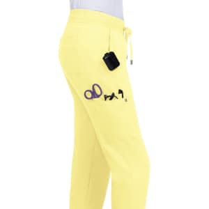 A pair of yellow jogger pants featuring pockets with scissors and other tools visible. The pants have a drawstring waistband.