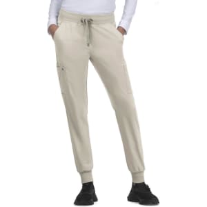 Beige jogger pants with a drawstring waist and side pockets, paired with black shoes. Features a casual fit.
