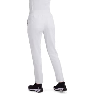White Atria Pant displayed from the back, featuring a fitted design and pockets, paired with black footwear.