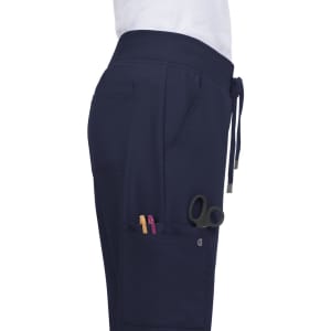 Navy Atria Pant featuring pockets with pens and scissors, designed for functionality and comfort.