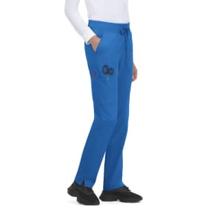 Atria Pant in blue, featuring pockets and a drawstring waist, displayed on a model wearing a white top and shoes.