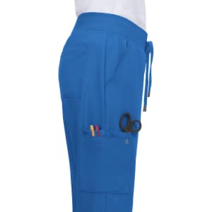 Atria Pant in bright blue featuring pockets with pens and scissors visible. Includes a drawstring waistband.