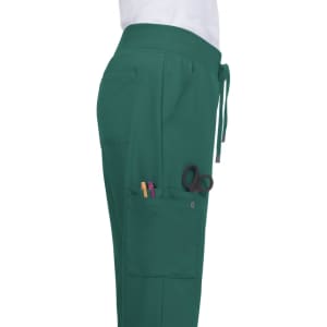 Atria Pant in teal, featuring pockets with pens and scissors, shown from the side. Includes a drawstring waistband.