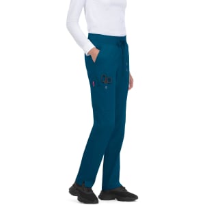 Atria Pant in teal with pockets and a waist drawstring, paired with a white top and black shoes.