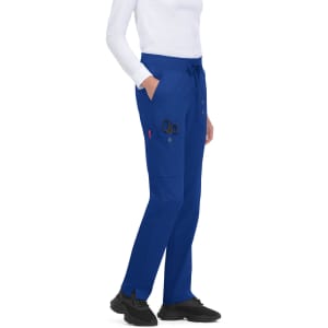 Atria Pant in royal blue, featuring pockets and a drawstring waistband. A person stands wearing the pants.