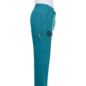 Atria Pant in teal with pockets, showcasing scissors and pens. Features a drawstring waistband for comfort.