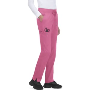 Pink Atria Pant with pockets and a logo, worn by a model, paired with black shoes.