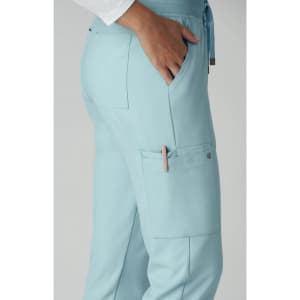 Atria Pant in light blue with pockets, showcasing a side view and a logo on the fabric.