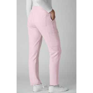 Atria Pant in pink featuring a fitted style and side pockets. The model is wearing white shoes.