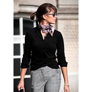 A black women's polo shirt styled with a scarf, worn by a woman outdoors.