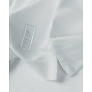 A white polo shirt featuring a logo, displayed with a focus on the fabric and collar details.