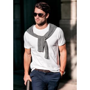 A white men's T-shirt with a grey sweater casually draped around the shoulders, paired with dark trousers and sunglasses.