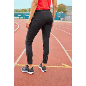 Black ladies' running pants featured on a track, with a fitted design and a logo on the side.