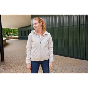 A light beige ladies bomber jacket with a hood, showcased on a woman standing in an outdoor setting.