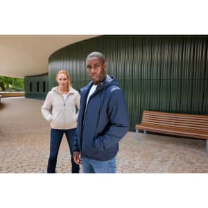 A ladies bomber jacket in light beige, worn by a model, alongside a model in a navy jacket. Both are outdoors.
