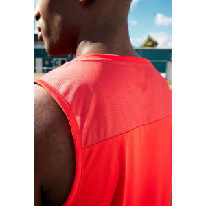 A men's running tank in bold red, featuring a mesh back and a logo. The fabric appears lightweight and breathable.
