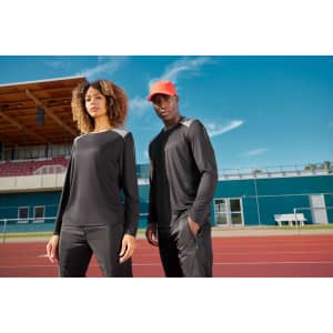 A long-sleeve men's running shirt in black, worn by a model on a track, featuring a logo.