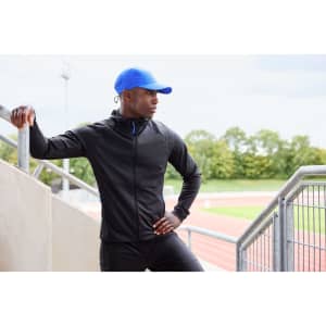 A black men's running jacket with a hood, paired with a blue cap, set against an athletic background.