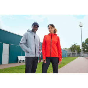 A grey softshell jacket and a red softshell jacket worn by models outdoors, both featuring logos.