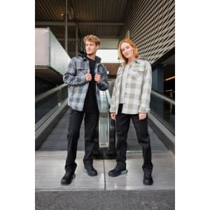 A check shirt jacket in grey and white, worn by a man and woman, paired with black pants and shoes.