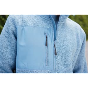 A light blue knitted fleece jacket with a zippered pocket and a logo on the chest area.