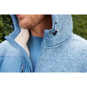 A soft shell jacket in a blue knit fleece design, featuring a hood and fleece lining, with a logo on the chest.