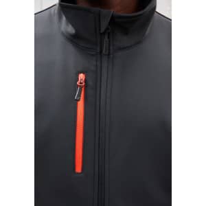 A black softshell jacket with a zippered pocket highlighted in bright orange. It has a high collar and a sleek design.