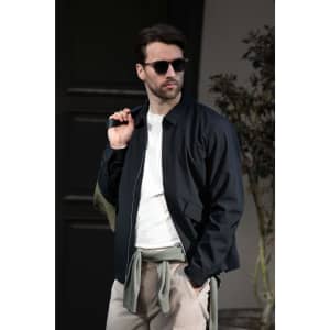 A unisex jacket in navy blue, worn by a man with sunglasses, styled casually with a light-coloured shirt.