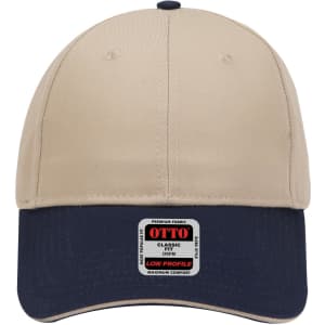 A beige and navy six-panel low profile baseball cap with a logo on the front.