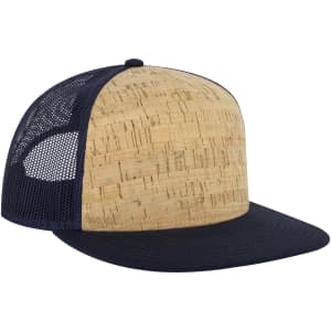 A 5 panel pro style trucker cap featuring a cork front and navy mesh sides. It has a solid navy brim and a logo.