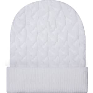 A white cable knit beanie with a rib knit cuff and a smooth finish. It features a logo on the cuff.