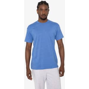 A man wearing a blue short sleeve cotton poly crew tee, standing against a plain background. The shirt has a logo.