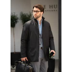 A black men's jacket is worn by a man holding a bag, set in a modern outdoor environment.