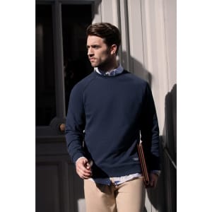 A navy sweatshirt worn by a man, with a logo visible. He is standing by a door, holding a folder.