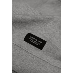 A grey sweatshirt featuring a label with branding details at the neckline.
