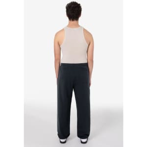 A person wearing dark grey heavy fleece sweatpants and a beige tank top, viewed from the back.