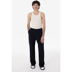 A model wearing straight leg heavy fleece pants in black, paired with a light tank top and sneakers.