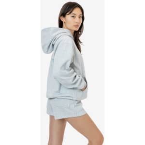 A light grey heavy fleece hood pullover displayed on a model, featuring a hood and a relaxed fit.