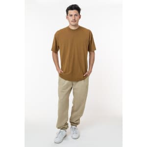A man wearing a brown t-shirt and light tan heavy fleece sweatpants, with a logo on the clothing.