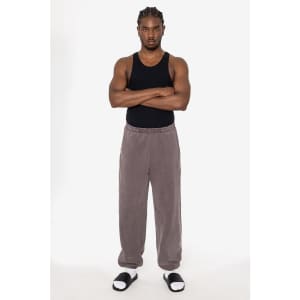 Heavy fleece sweatpants in a muted grey colour, featuring an elastic waistband and a relaxed fit. Model is wearing a black tank top.