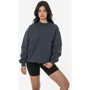 A woman wearing a dark grey heavy fleece pullover and black bike shorts, posing against a plain background.