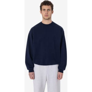A heavy fleece pullover in navy blue, featuring a crew neck and long sleeves, paired with light grey pants.