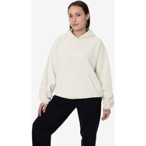 A light cream heavy fleece hooded pullover with a front pocket, worn by a model against a plain background.