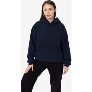 A woman wearing a navy blue Garment Dye Heavy Fleece Hooded Pullover with a front pocket and a relaxed fit.