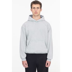 A grey mineral wash heavy fleece hooded pullover with a front pocket. The model stands with a neutral expression.